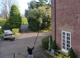 An image of a Ultimate Cleaning Solutions team member cleaning a gutter
