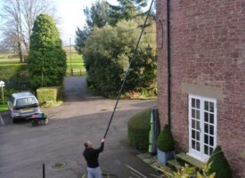 An image of a Ultimate Cleaning Solutions team member cleaning a gutter