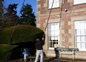 An image of a Ultimate Cleaning Solutions team member cleaning a gutter