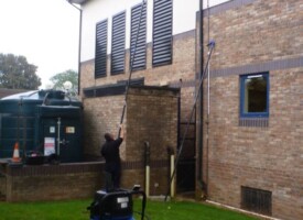 An image of a Ultimate Cleaning Solutions team member cleaning a gutter