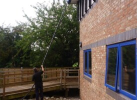 An image of a Ultimate Cleaning Solutions team member cleaning a gutter