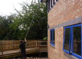 An image of a Ultimate Cleaning Solutions team member cleaning a gutter